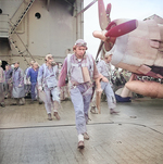 US Navy pilots Ensign Charles Miller, Lieutenant (jg) Henry Dearing, and Lieutenant (jg) Bus Alber walking toward their aircraft aboard USS Saratoga, 5 Nov 1943; note F6F fighter