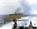 Carrier Ticonderoga burning after being struck by special attack aircraft off Taiwan, 21 Jan 1945; note light cruiser Miami