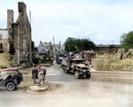 Convoy of US CCKW 2 1/2-ton 6x6 transport trucks moving inland after heavy equipment cleared the road, Normandy, France, 1944; note Jeeps and heavy earth moving equipment