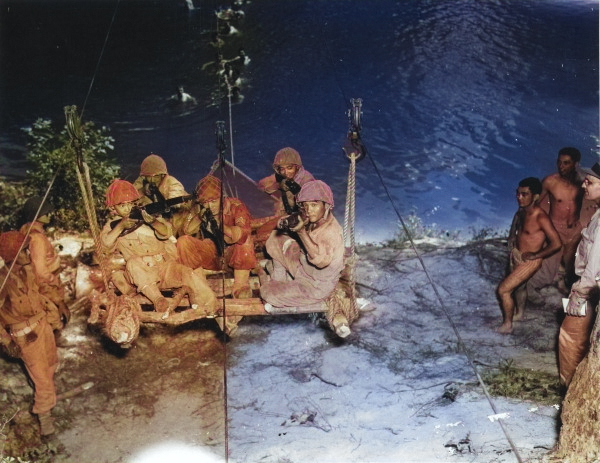 Japanese-American recruits of US 442nd Regimental Combat Team preparing to cross a stream on a raft swung on cables and pulled by men in the water, Camp Shelby, Mississippi, United States, 1943 [Colorized by WW2DB]