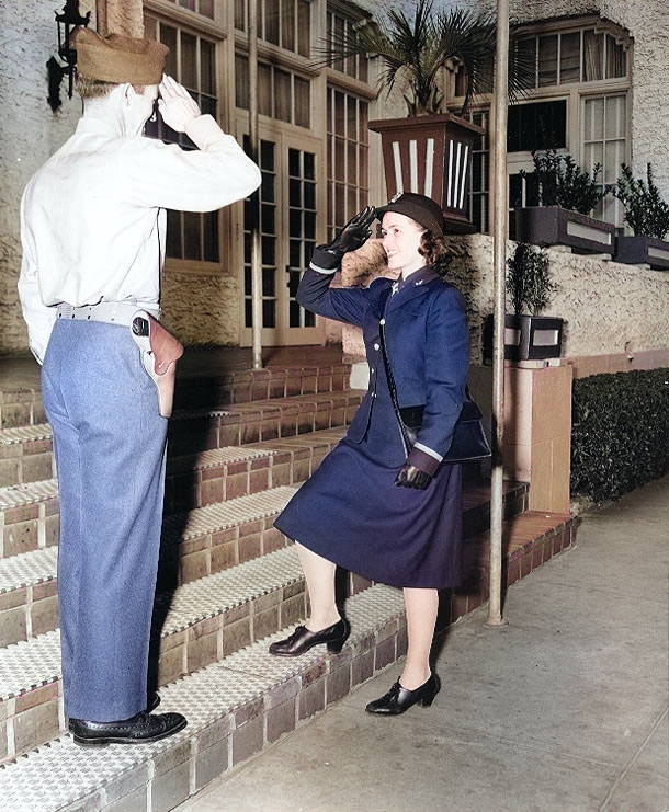 WAVES Ensign Emma D. Shelton received salute from a US Marine sentry s she enters an apartment building that served as temporary WAVES quarters, circa 1943 [Colorized by WW2DB]