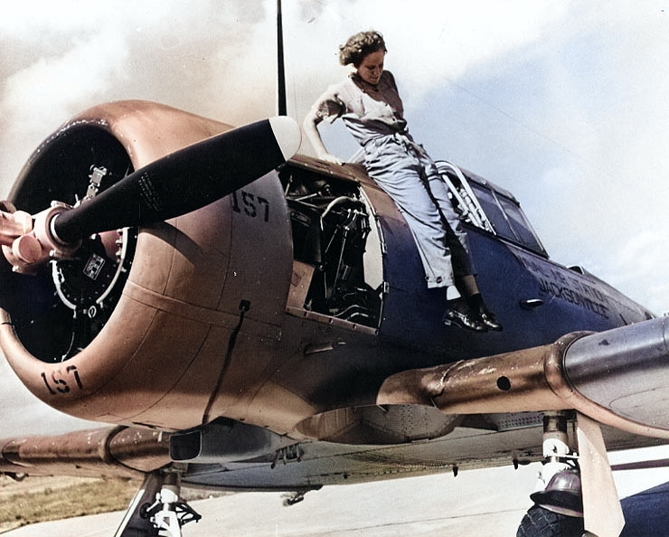 WAVES Aviation Machinist's Mate Mary Arnold jumping down from the fuselage of a SNJ training aircraft, Naval Air Station, Jacksonville, Florida, United States, 4 Nov 1943 [Colorized by WW2DB]