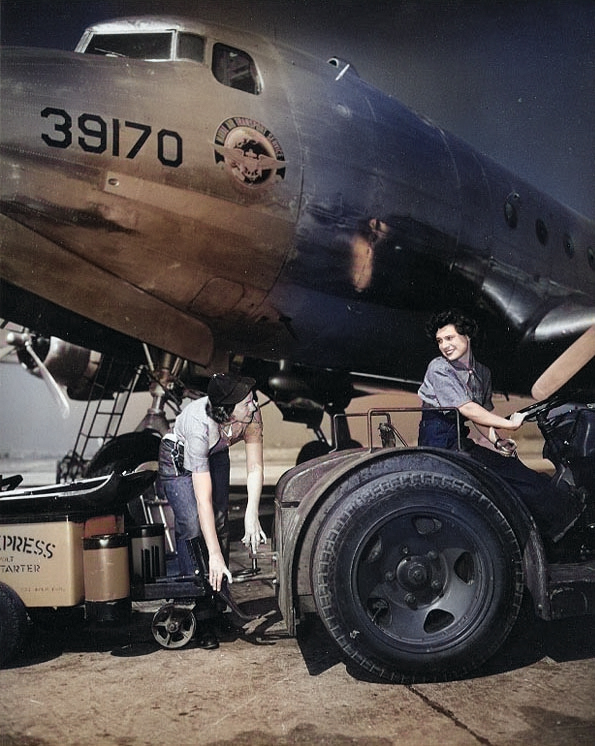 WAVES Seamen 1st Class Billy Ikard and Barbara A. Patterson moving a battery cart into position next to a R5D Skymaster aircraft, Naval Air Station, Oakland, California, United States, circa mid-1945 [Colorized by WW2DB]