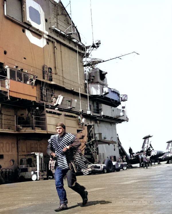 Seaman Leroy Kellam of Essex carried belts of 20mm ammunition for a F2H Banshee fighter aircraft, off Korea, 12 Oct 1951 [Colorized by WW2DB]