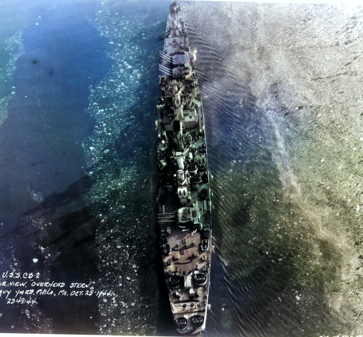 Aerial view of large cruiser Guam, Philadelphia Navy Yard, Pennsylvania, United States, 25 Oct 1944, photo 5 of 5 [Colorized by WW2DB]