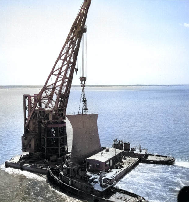 The bow of USS Kentucky being transported on a crane en route between Newport News to Norfolk, Virginia, United States, to be fitted on USS Wisconsin, circa May-Jun 1956 [Colorized by WW2DB]