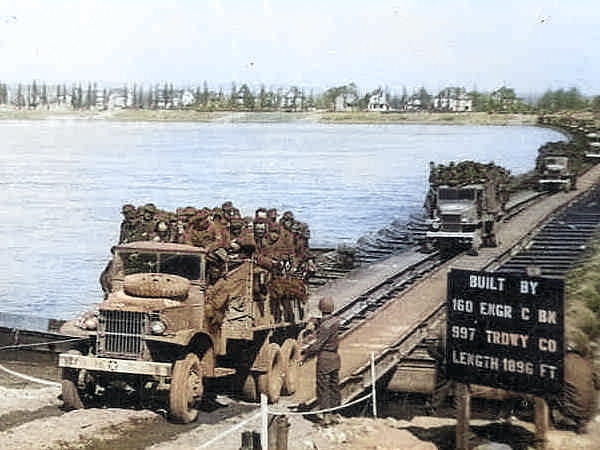 US Army CCKW 2 1/2-ton cargo trucks crossing the Rhine River near Mainz, Germany, Mar or Apr 1945; the passengers were possibly German POWs [Colorized by WW2DB]