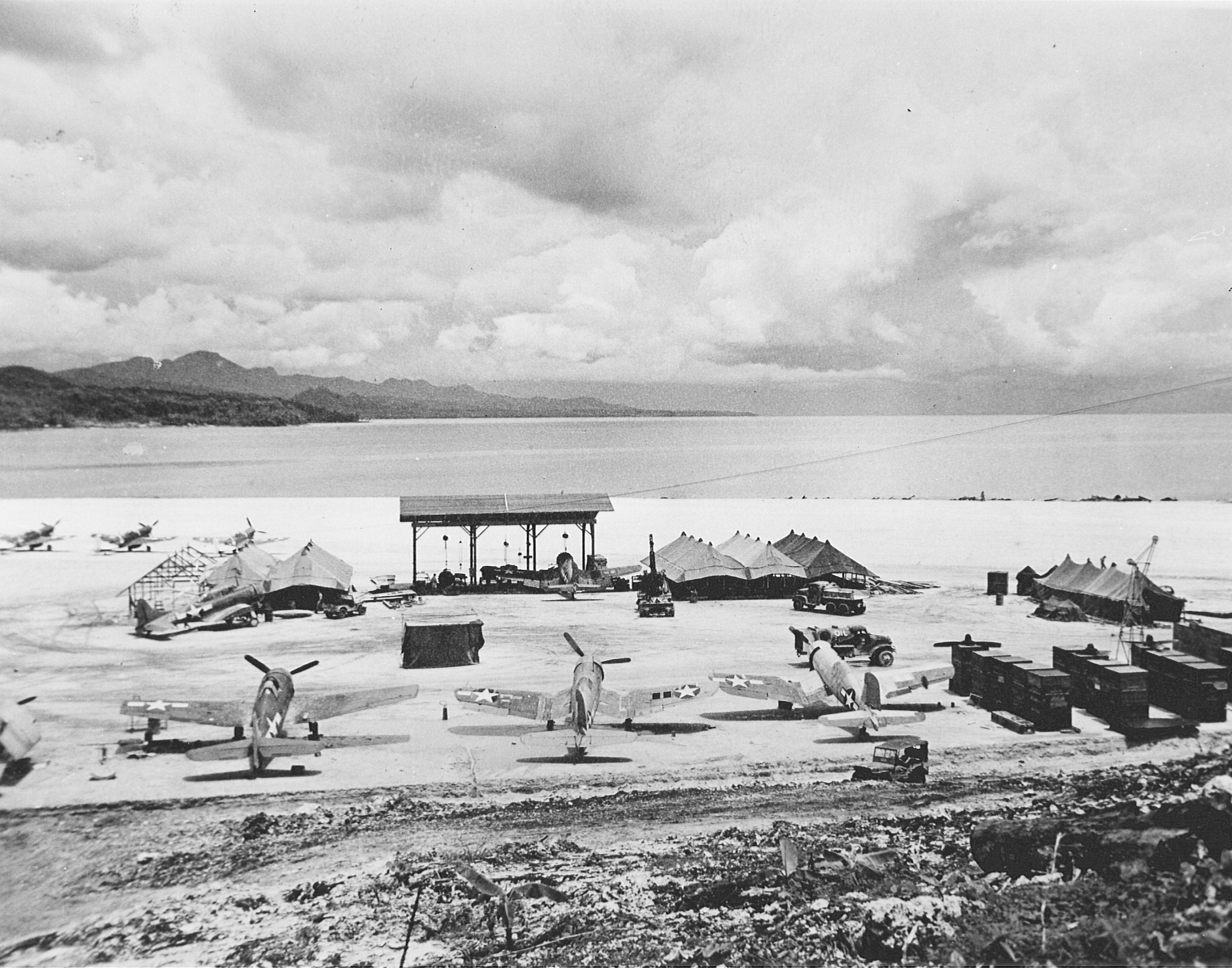US F4U-1 Corsair, US F6F-3 Hellcat, US SBD Dauntless, and New Zealand Kittyhawk Mk. IV aircraft at the Barakoma airfield at Vella Lavella, Solomon Islands, 10 Dec 1943