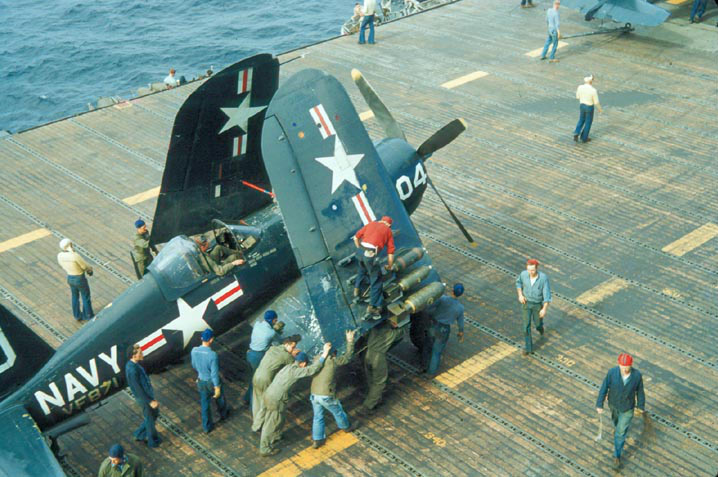 F4U-4 Corsair fighter of US Navy squadron VF-871 being prepared for a mission aboard USS Essex, off Korea, summer or fall 1952