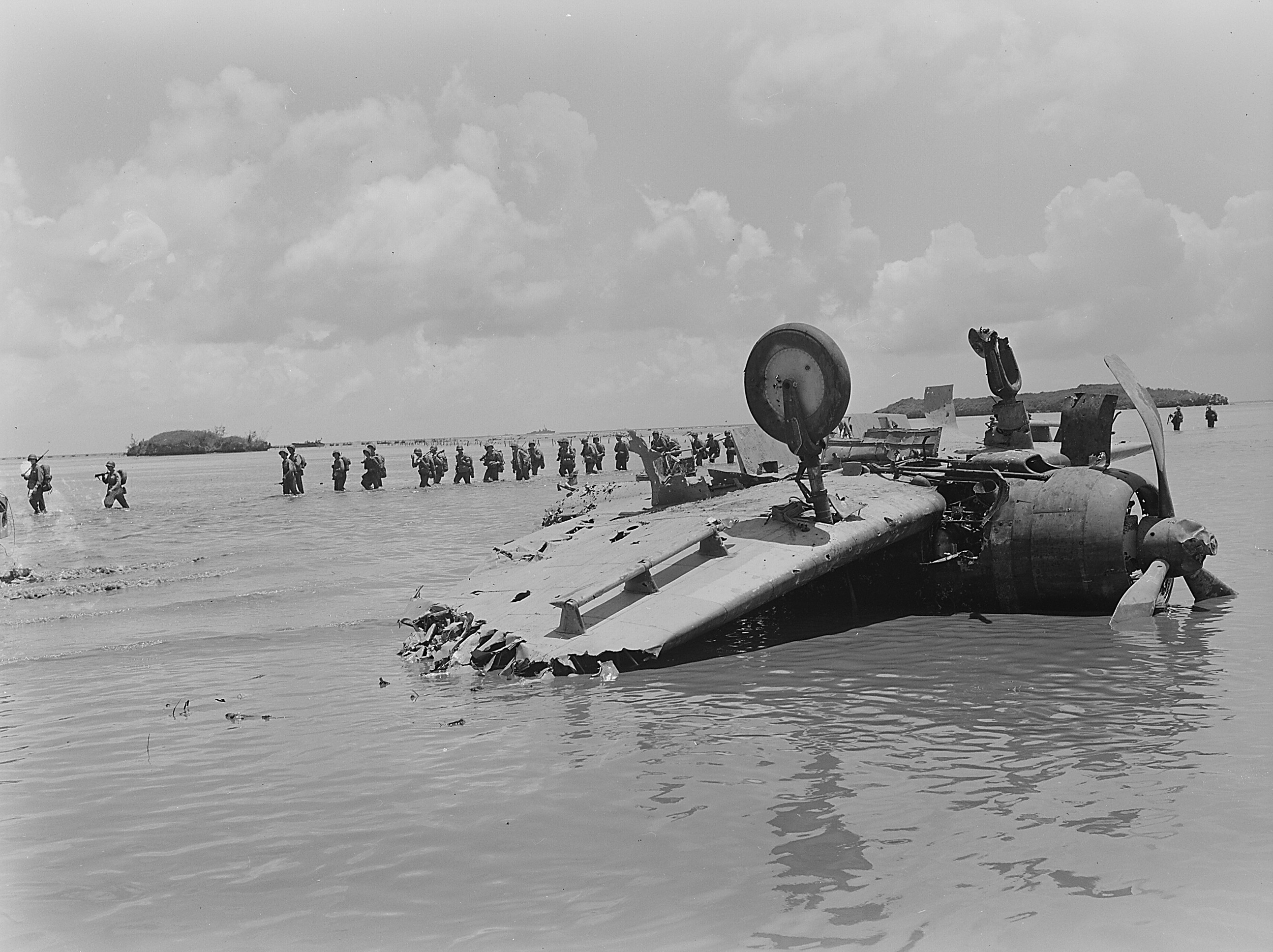 US Marines wading past wreckage of a D3A dive bomber, Agat beachhead, Guam, Mariana Islands, Jul 1944