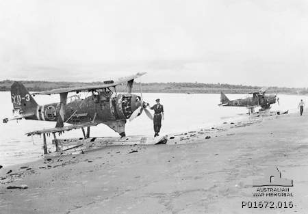 Two damaged Japanese F1M2 biplanes on the beach at Rekata Bay, Santa Isabel, Solomon Islands, Mar 1944; note RNZAF Flight Lieutenant J. Beattie in foreground