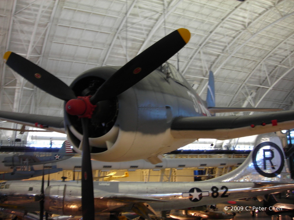 F6F-3 Hellcat fighter on display at the Smithsonian Air and Space Museum Udvar-Hazy Center, Chantilly, Virginia, United States, 26 Apr 2009, photo 2 of 4; note B-29 bomber Enola Gay in background