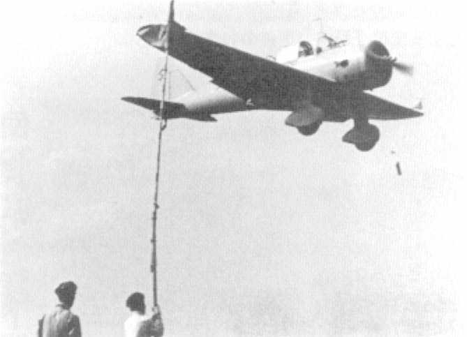 Ki-36 aircraft in flight over an airfield, circa 1940s