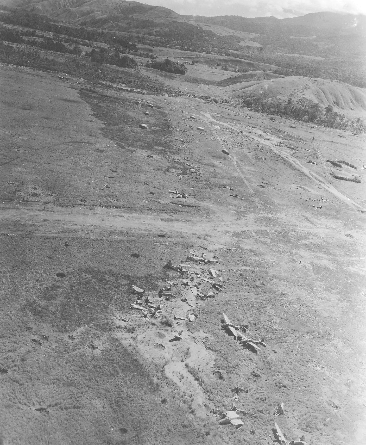 Bomb Damage Assessment photo of destroyed Ki-48 bombers at a Japanese airstrip in northern New Guinea, 1942-1943, photo 2 of 2; note open parachutes in upper center (bombs or supplies?)