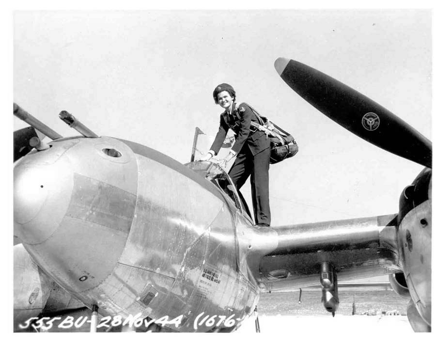 WASP pilot Ruth Dailey climbing into a P-38 Lightning aircraft, 28 Nov 1944