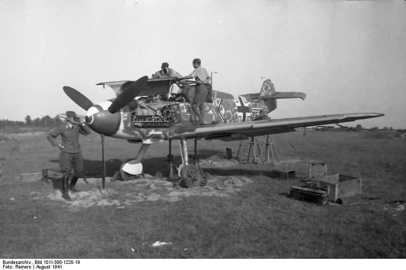 German crew sighting the 20mm cannon on a Bf 109F fighter of JG 54 'Grünherz' fighter wing, near Leningrad, Russia, Aug 1941, photo 1 of 2