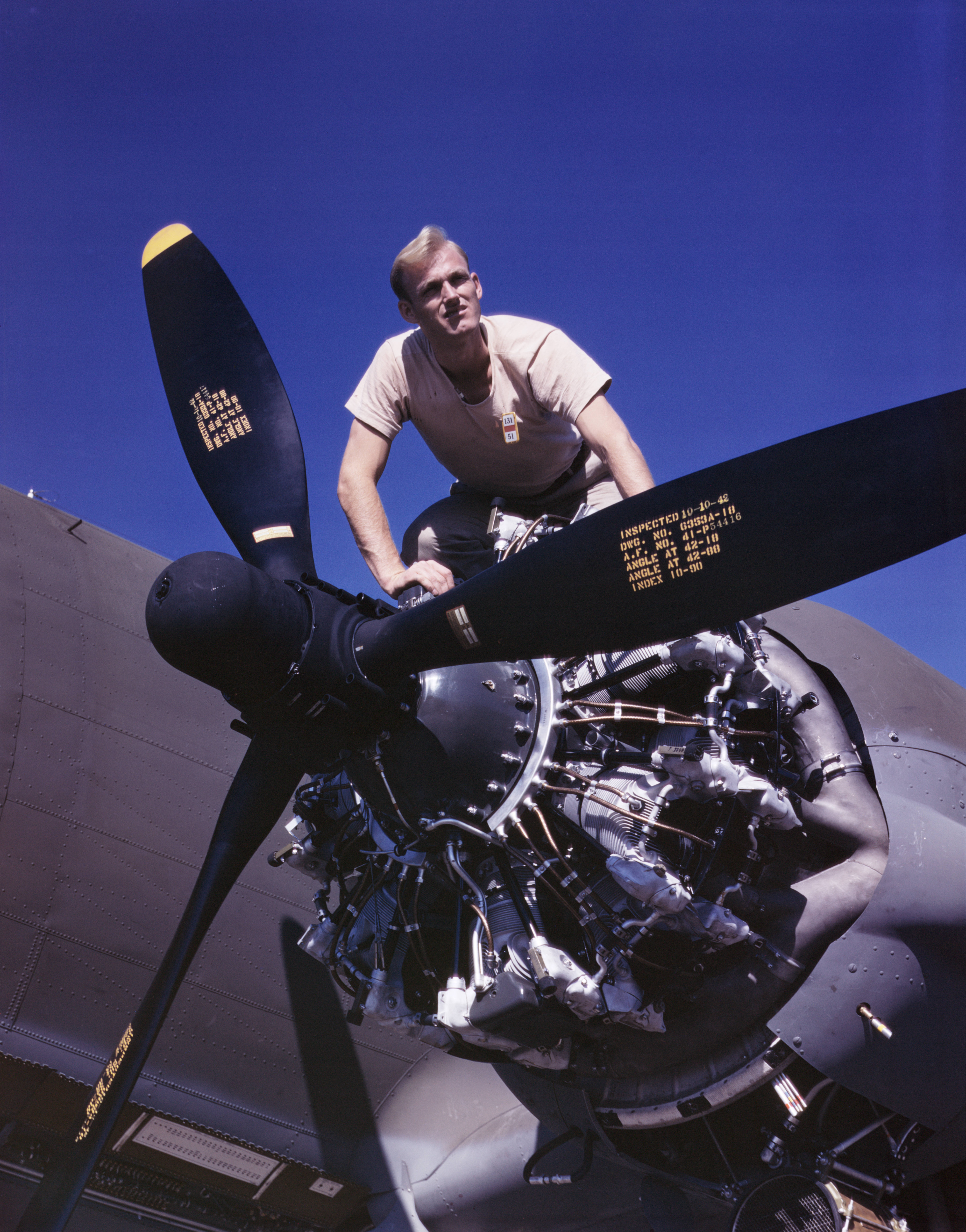 Douglas Aircraft Company employee working on the port engine of a C-47 Skytrain aircraft, Long Beach, California, United States, Oct 1942