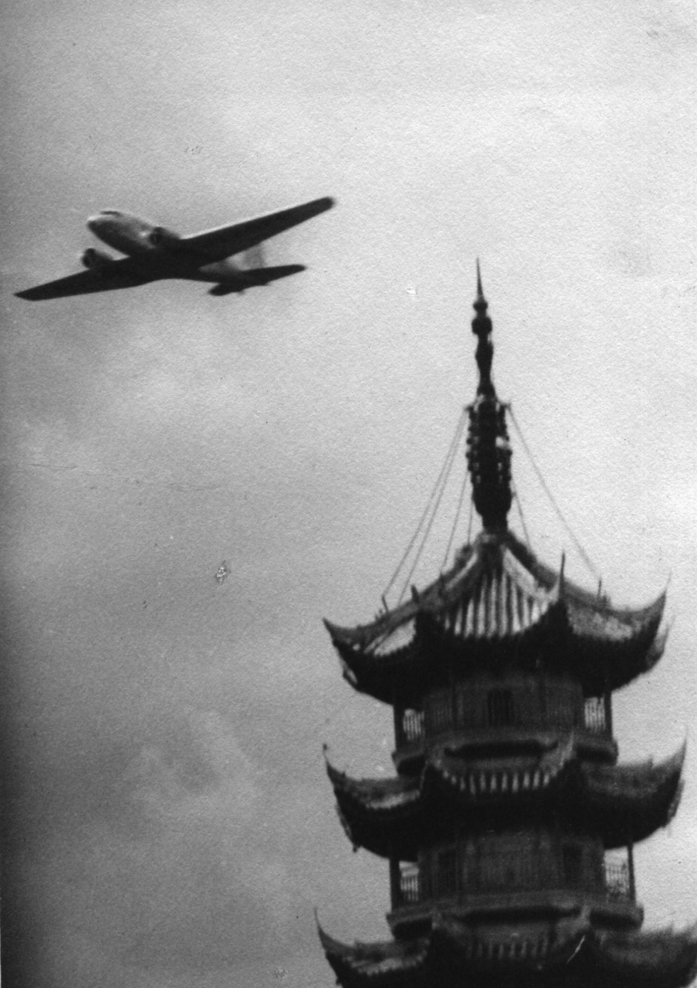 DC-2 passenger aircraft of China National Aviation Corporation on its maiden flight, over the pagoda of Longhua Temple, Shanghai, China, May 1935
