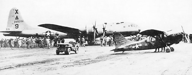 B-29 Superfortress bomber 'Dinah Might' after making an emergency landing at Motoyama Airfield No. 1, Iwo Jima, Japan, 4 Mar 1945; note USMC OY-1 Sentinal of VMO-4 and MB or GPW Jeep in foreground