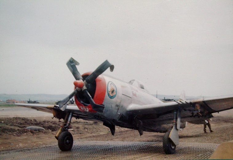 Captain Paul Hall's P-47D Thunderbolt fighter 'Dixie Gal' of 57th Fighter Group, US 64th Fighter Squadron at rest at Grosseto, Italy, Oct 1944-May 1945; note damaged propellers and A-26 in background