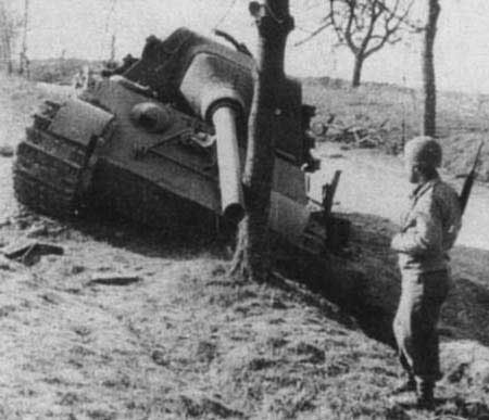 An American soldier looking at a knocked out German Jagdtiger tank, Morsbronn area, Alsace, France, Mar 1945
