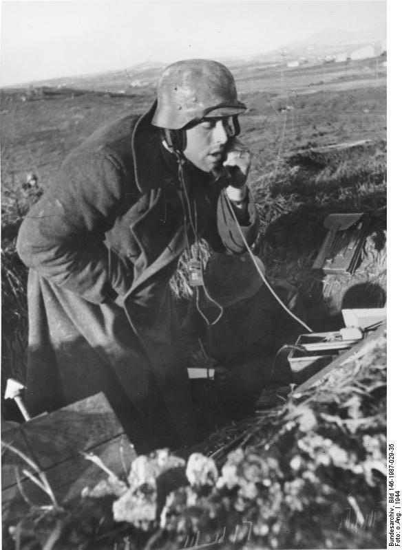 German anti-aircraft gun crewman speaking into a field telephone, near Nettuno, Italy, 1944