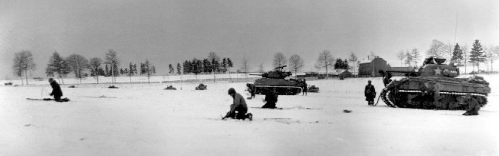 Troops of US 44th Armored Infantry Battalion and M4 Sherman tanks of US 6th Armored Division advancing toward German lines near Bastogne, Belgium, 31 Dec 1944