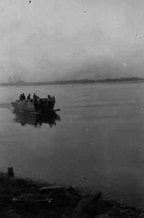 1st Squad of A Company of US 150th Combat Engineer Battalion crossing the Rhine River in Germany by an US Navy landing craft, 23 Mar 1945