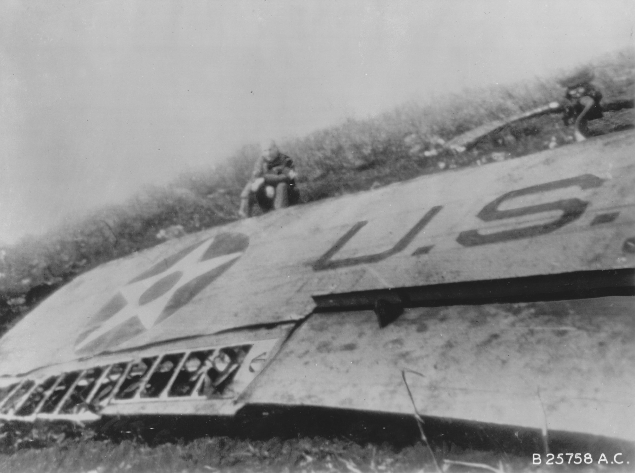 James Doolittle sitting by the wing of his wrecked B-25 Mitchell bomber, China, 18 Apr 1942