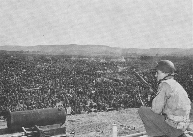 American soldier guarding a corner of a German prisoners of war camp near Remagen, Germany, 25 Apr 1945