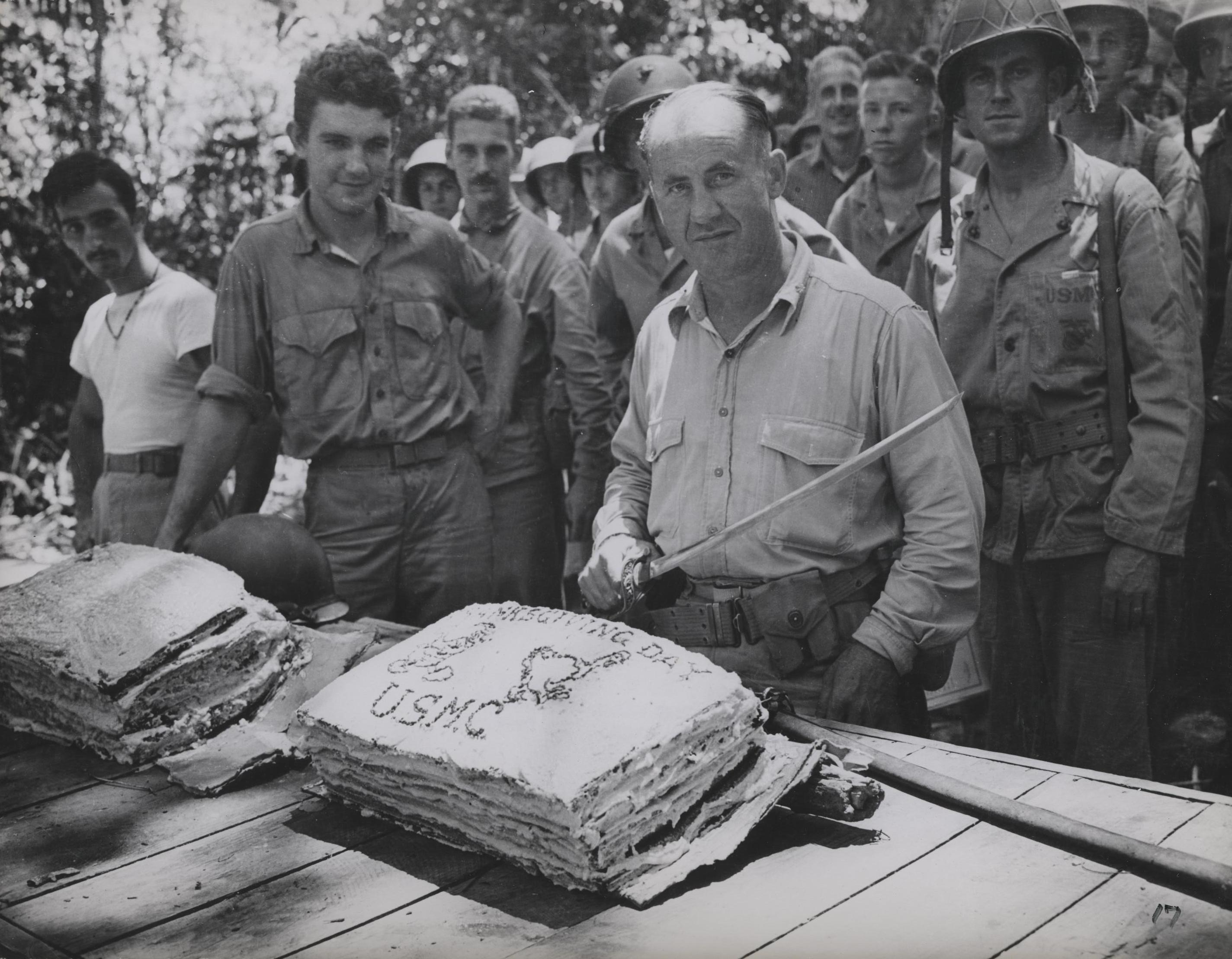 USMC Lieutenant Colonel W. W. Stickney preparing to cut a Thanksgiving holiday cake with a captured Japanese sword, Guadalcanal, Solomon Islands, circa 26 Nov 1942