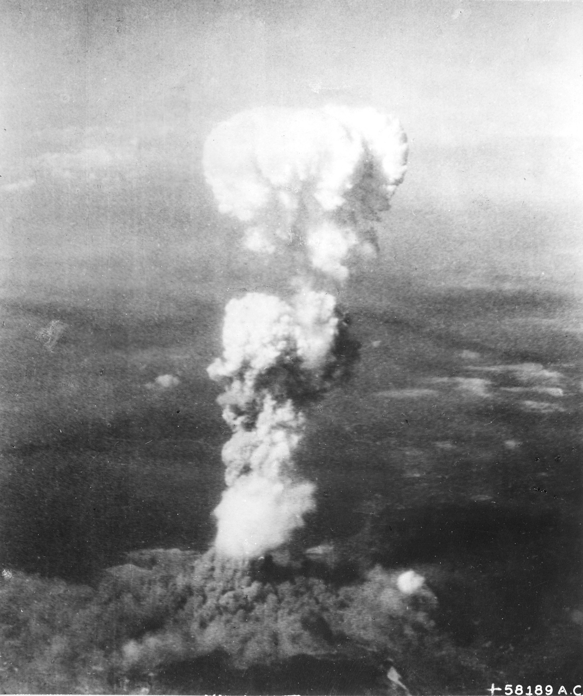 Mushroom cloud rising over Hiroshima, Japan seen from B-29 bomber Necessary Evil, 6 Aug 1945