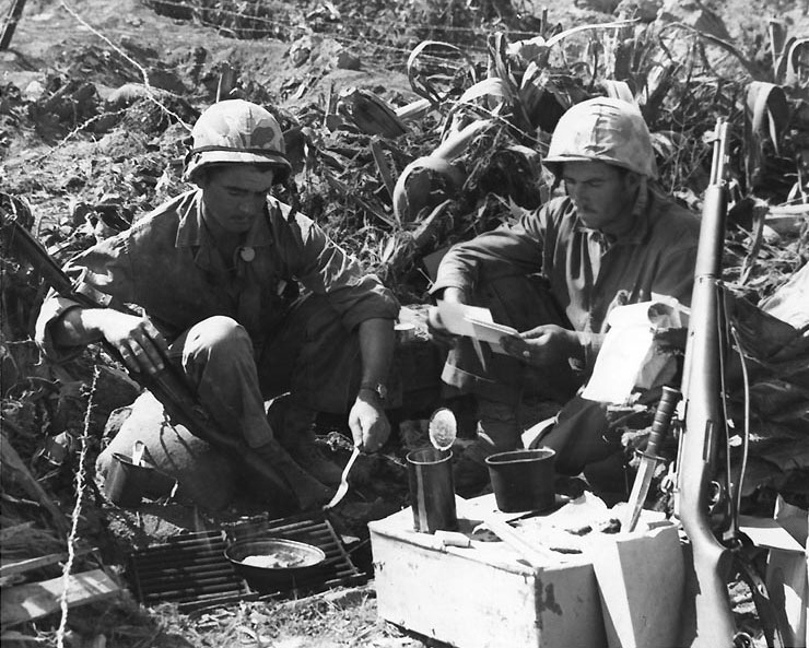 Private First Class H. L. Miles and Corporal C. V. Corley of US Marines rested during a lull in battle, Iwo Jima, Japan, 15 Mar 1945