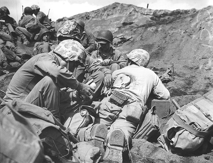US Navy Corpsman dressed a back wound of a Marine who was hit by the enemy in the battle on Iwo Jima, Feb 1945