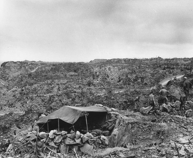 Sandbag, rock and canvas shelter in the rugged terrain of northern Iwo Jima, 21 Apr 1945