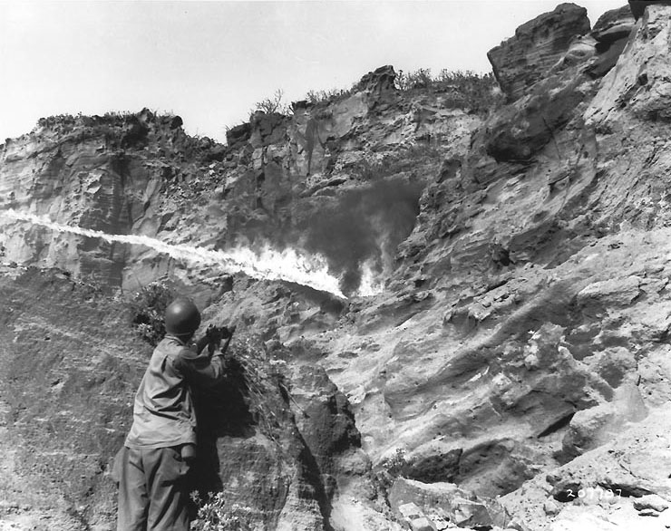 Flame thrower in use against Japanese holding out in a cave along Iwo Jima's northern coastal cliffs, 8 April 1945