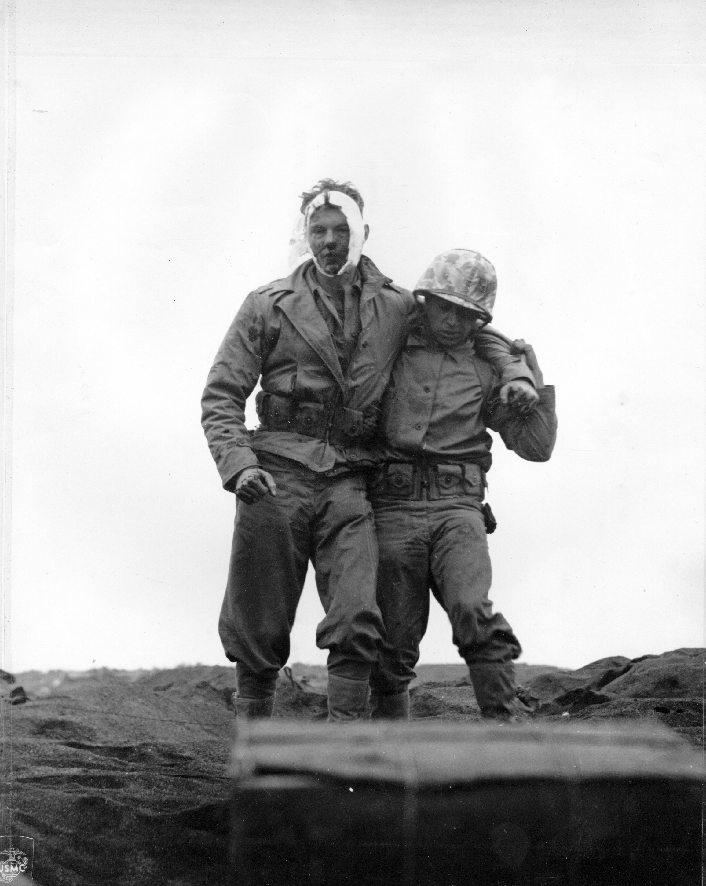 Wounded US Marine being helped by a comrade, Iwo Jima, Japan, 20 Feb 1945