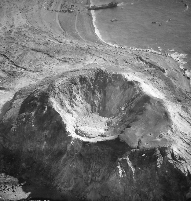 Aerial photograph of Mount Suribachi with Iwo Jima's Beach Green One beyond, circa 20-28 Feb 1945