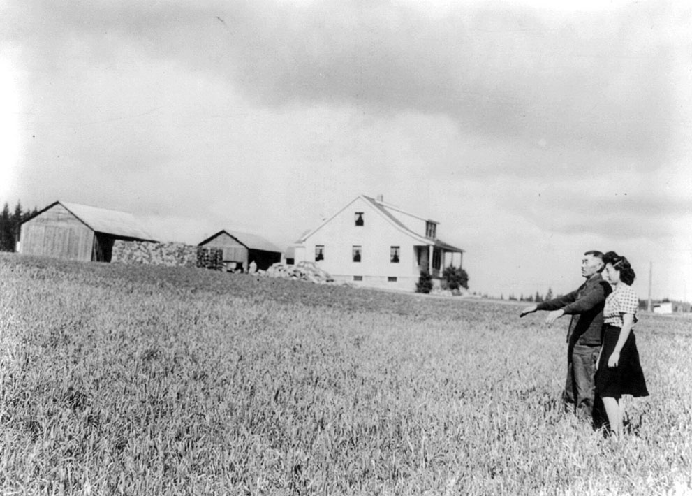 A Japanese-American farmer and his daughter taking a look of their strawberry farm before being relocated, Bainbridge Island, Washington, United States, 23 Mar 1942