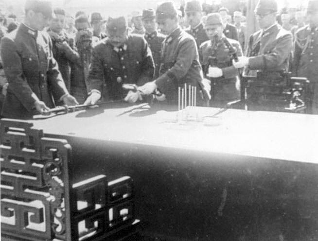Lieutenant General Hiroshi Nemoto surrendering his sword at the Japanese surrender ceremony at the Forbidden City, Beiping, China, 10 Oct 1945