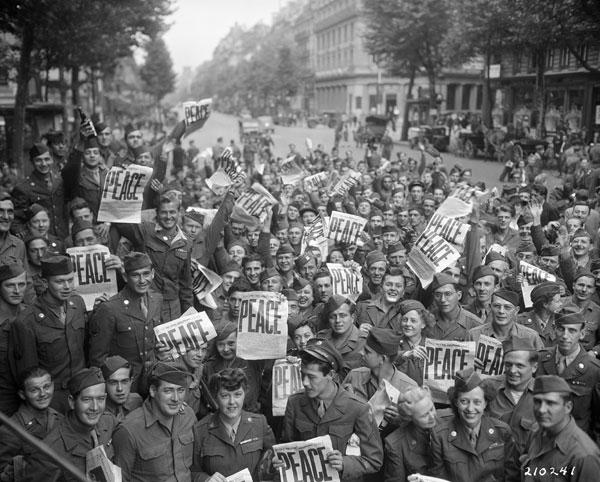 American servicemen and women gathered in front of 'Rainbow Corner' Red Cross club in Paris, France to celebrate the unconditional surrender of the Japanese, 15 Aug 1945
