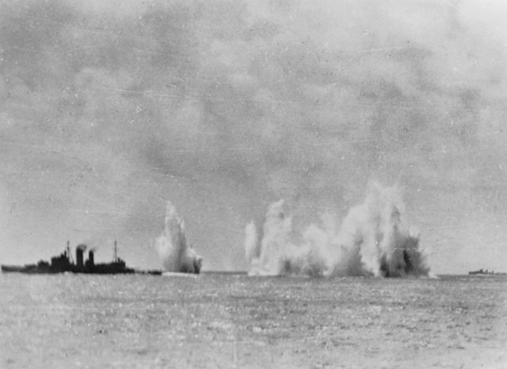 Cruiser Exeter under air attack by B5N aircraft in the Gaspar Strait, 15 Feb 1942; note bombs falling astern of the cruiser