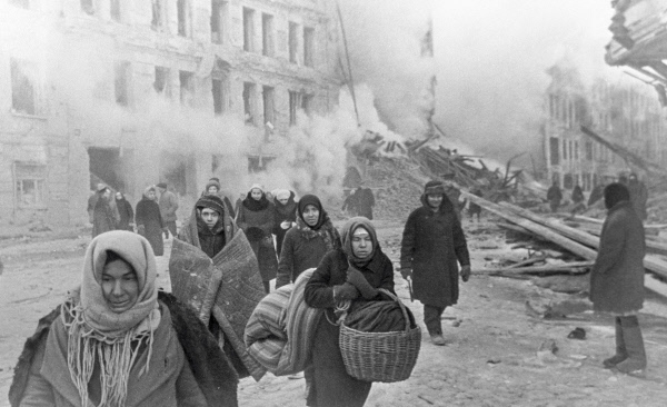 Russian civilians on a street in Leningrad, Russia, 10 Dec 1942; note damaged building in background