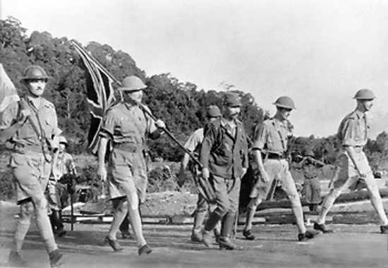 British Army Lieutenant General Arthur Percival and his party carrying the United Kingdom flag and a white flag on their way to surrender Singapore to the Japanese, 15 Feb 1942, photo 1 of 2