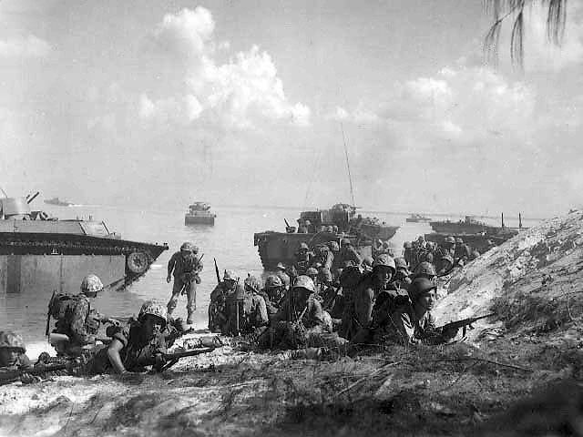 Men of the first wave of US Marines to land on Saipan, Mariana Islands crawling forward cautiously, 15 Jun 1944