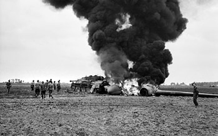 An American C-47 aircraft, hit by flak returning from the Market-Garden drop, burning after crash-landing into a knocked-out German Jagdpanther near Gheel, Belgium, 17 Sep 1944