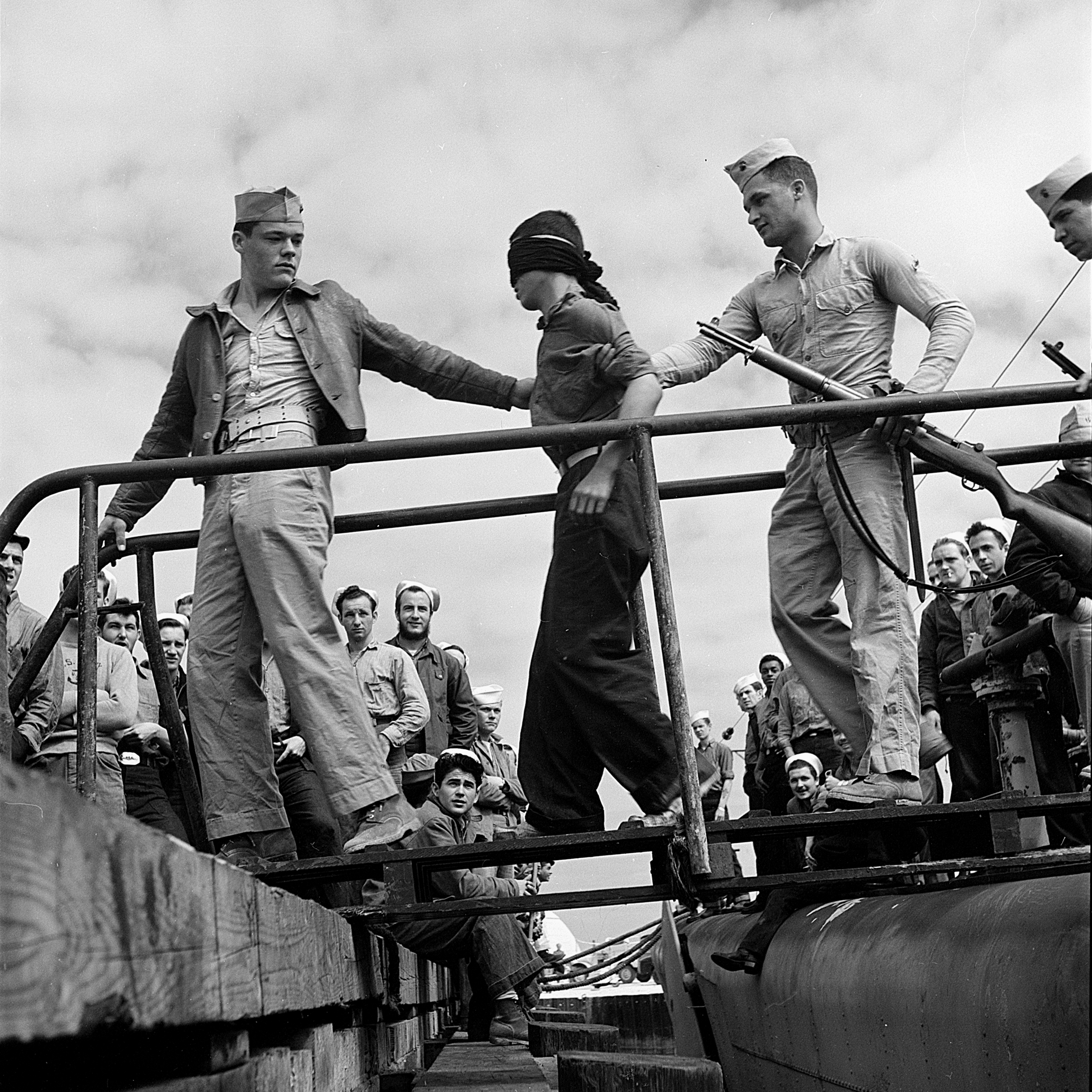 US Marines unloading Japanese prisoner of war from a submarine, May 1945