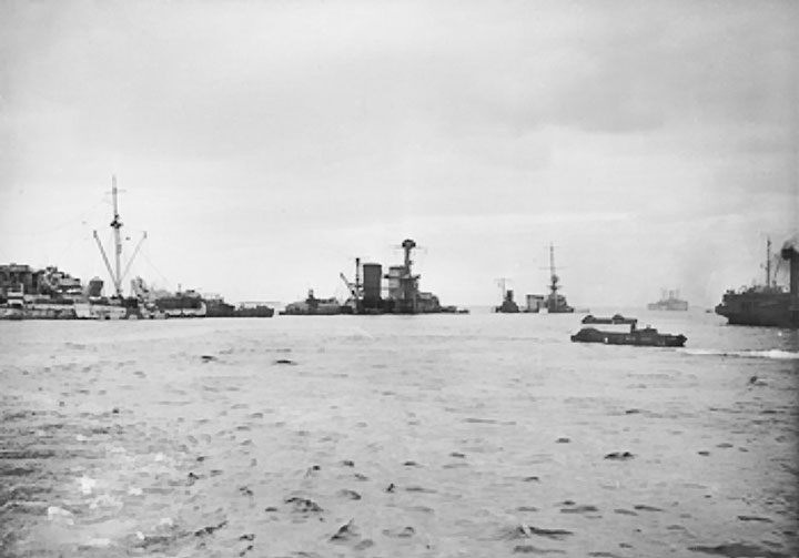 A Gooseberry line of block ships off the Normandy beaches, Ouistreham, France, Jun 1944; note sunken British ship Durban, sunken Dutch ship Sumatra, and two active DUKW craft