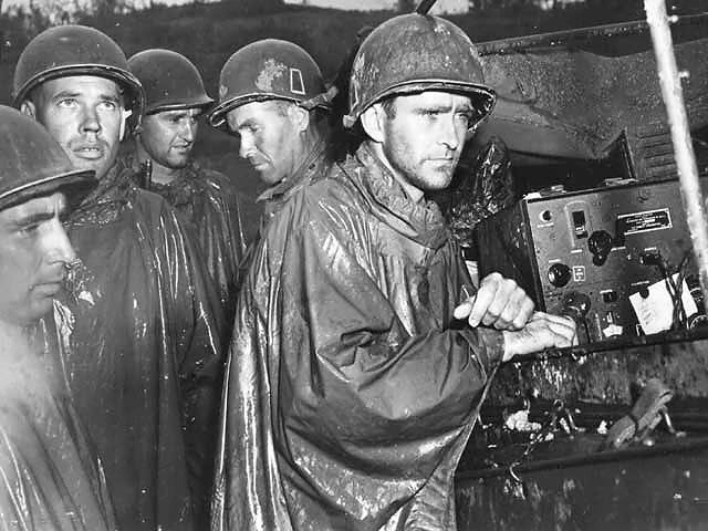 Men of the US Army 77th Infantry Division at Okinawa, Japan listening to radio reports for the German surrender, 8 May 1945