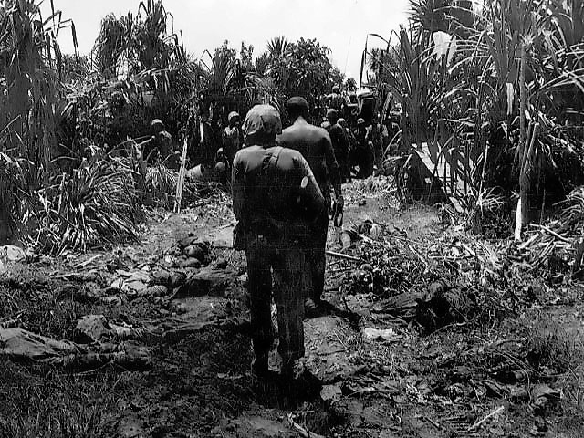 US Marines walking past dead Japanese as they moved on the peninsula on Peleliu, Palau Islands, Oct 1944